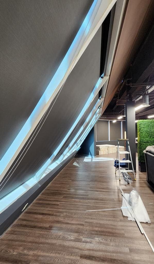 Installation of blackout roller shades in a modern commercial space.