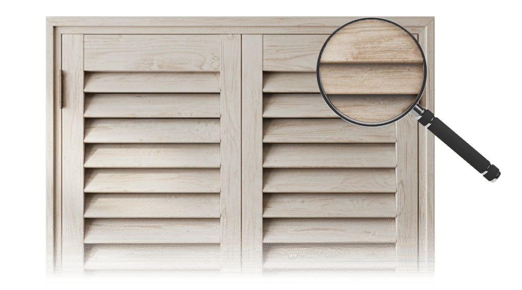 Close-up view of light-colored wooden shutters showing smooth basswood texture and finely crafted louvers.
