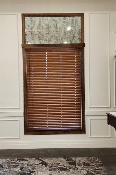 A room with a pool table and a window, featuring horizontal blinds.