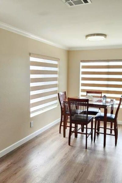 An inviting living room with a comfortable couch and a window with blinds and dual shades.